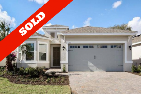 Newly built home with "SOLD" overlay, featuring a modern exterior, landscaped yard, and two-car garage, located in a desirable 55+ community in Kissimmee, Florida.