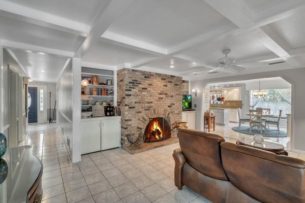 Family room featuring a cozy brick fireplace, built-in shelves, and comfortable seating, showcasing an inviting space in a Windermere home for sale at 1421 Crescent Lake Dr.