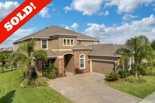 Sold-overlay-15455-768x509-1-600x400 Sold home at 15455 Sandfield Loop in Winter Garden, featuring a spacious exterior with tropical landscaping, driveway, and palm trees under a blue sky.