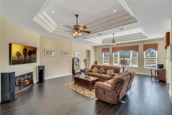 Spacious living room in Winter Garden, Florida home featuring elegant ceiling design, large windows with natural light, comfortable seating, and modern entertainment setup.