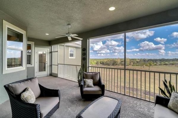 Screened lanai with comfortable seating, showcasing scenic views of the surrounding landscape at 11630 Flynn Ct, Winter Garden, FL, emphasizing outdoor living space and tranquility.