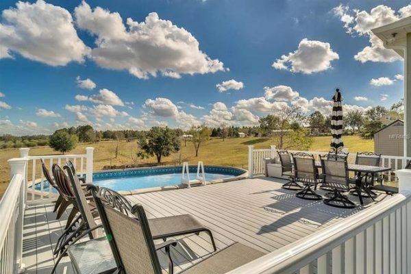 Poolside deck with seating area, above-ground saltwater pool, and expansive views of the surrounding landscape at 11630 Flynn Ct, Winter Garden, FL.
