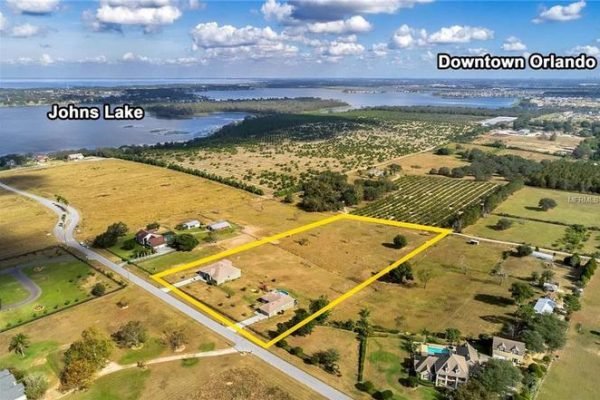 Aerial view of 11630 Flynn Ct, Winter Garden, FL, showcasing a spacious 5-acre estate with two homes, surrounding farmland, and proximity to Johns Lake and Downtown Orlando.