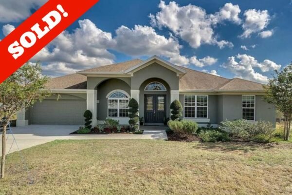 Single-family home exterior with "SOLD!" overlay, located in Winter Garden, FL, showcasing a landscaped yard and driveway, reflecting a successful real estate transaction.