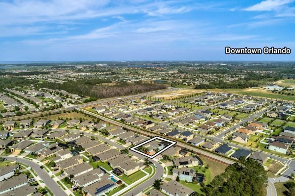 Aerial view of 15390 Sandfield Loop in Winter Garden, FL, showcasing surrounding residential neighborhoods, proximity to Downtown Orlando, and marked location of the property for sale.