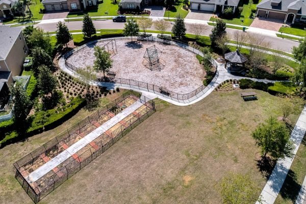 Aerial view of a community park in Winter Garden, FL, featuring a playground, walking paths, and landscaped areas, highlighting the recreational amenities available in the neighborhood.