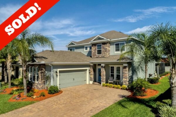 Sold-overlay-15390-600x400 Sold home at 15390 Sandfield Loop in Winter Garden, FL, featuring a stone-accented exterior, landscaped yard, and palm trees, with a prominent "SOLD!" overlay.