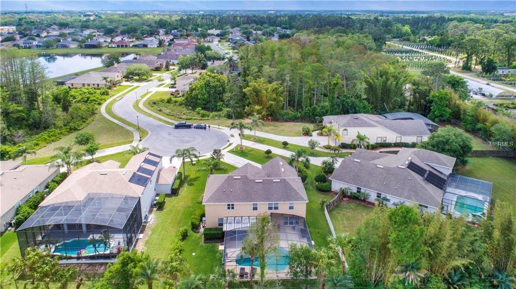 Aerial view of residential neighborhood in Winter Garden, Florida, showcasing houses with pools, landscaped yards, and winding roads, emphasizing the local real estate market.
