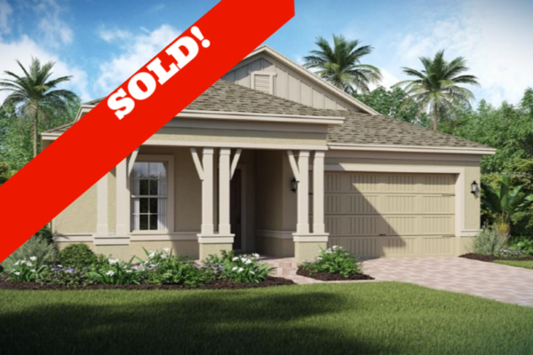 Single-family home exterior featuring a sold sign, lush landscaping, and palm trees in a residential setting, indicative of properties in Saint Cloud, FL.