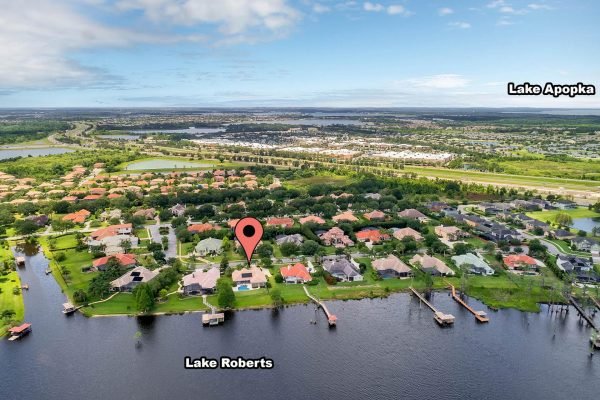 Aerial view of 2039 Water Key Drive in Windermere, FL, highlighting its location near Lake Roberts, with nearby residential properties and lush greenery.