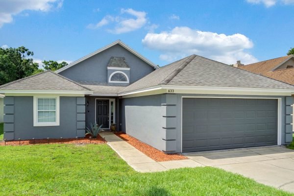 633-Remington-Oak-Dr-Lake-Mary-FL-32746-02-Front-600x400-1 Front view of 633 Remington Oak Dr, Lake Mary, FL, featuring a modern gray exterior, landscaped yard, and garage, highlighting a well-maintained home ideal for families near schools and amenities.