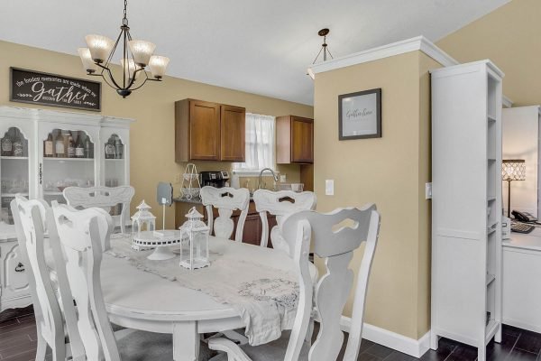 Dining area featuring a white table and chairs, light fixture, and kitchen cabinets, showcasing a cozy and inviting atmosphere in a home at 633 Remington Oak Dr, Lake Mary, FL.