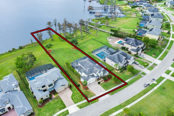Aerial view of a lakefront property at 1837 Lake Roberts Landing Dr, Winter Garden, FL, featuring spacious lawn, neighboring homes, and access to Lake Roberts.
