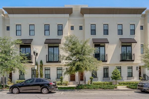 Luxurious brownstone exterior at 647 E Jackson St, Orlando, featuring three stories, modern architecture, and landscaped front yard, ideal for downtown living.