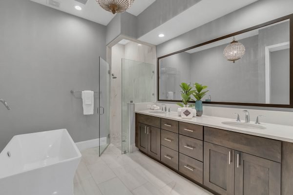 Luxurious bathroom featuring a freestanding tub, modern glass shower, double vanity with dark wood cabinetry, and stylish decor, ideal for upscale living in downtown Orlando.