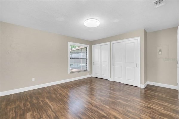 Spacious interior of a remodeled home featuring hardwood floors, large window, and double doors, ideal for showcasing the updated living space in the Windermere real estate market.