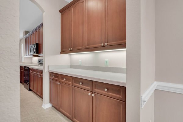 Kitchen interior with wooden cabinets, countertop, and modern appliances, showcasing a well-designed space in a Windermere home for sale.