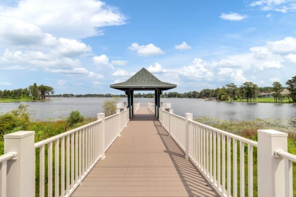 Scenic view of a wooden dock leading to a gazebo over a serene lake in Windermere, showcasing the community's natural beauty and outdoor amenities.