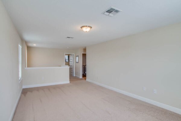 Spacious living area in a newly built home on Shallow Water Dr, featuring neutral walls and carpet, ideal for modern family living in Winter Garden, FL.