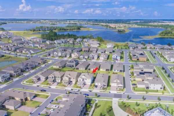 Aerial view of residential neighborhood in Winter Garden, Florida, showcasing homes with modern architecture, green lawns, and nearby lakes, highlighting the location of 10175 Shallow Water Dr.