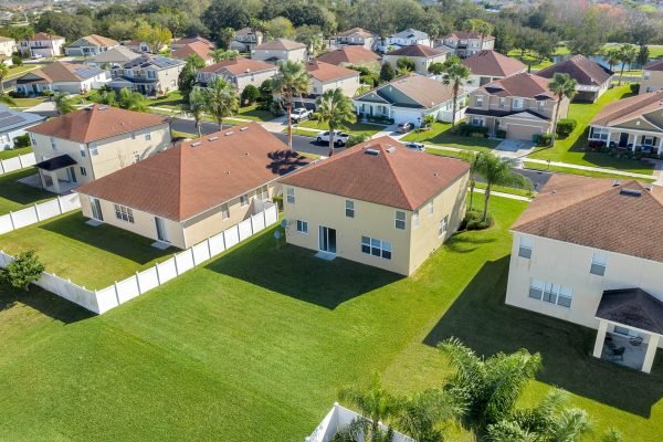 Aerial view of residential homes in a gated community in Winter Garden, FL, showcasing well-maintained lawns and proximity to amenities, relevant to the property listing at 592 First Cape Coral Dr.