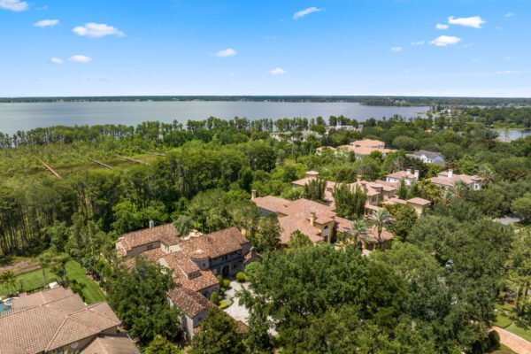 Aerial view of luxury homes and lush greenery surrounding Lake Butler, showcasing the exclusive neighborhood of Windermere, Florida, highlighting the lakefront lifestyle and natural beauty.