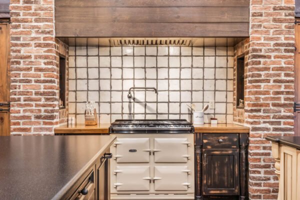 Luxury kitchen featuring a vintage-style range oven, rustic brick accents, and a tiled backsplash, highlighting the sophisticated design of the home at 11019 Bridge House Road in Windermere, FL.