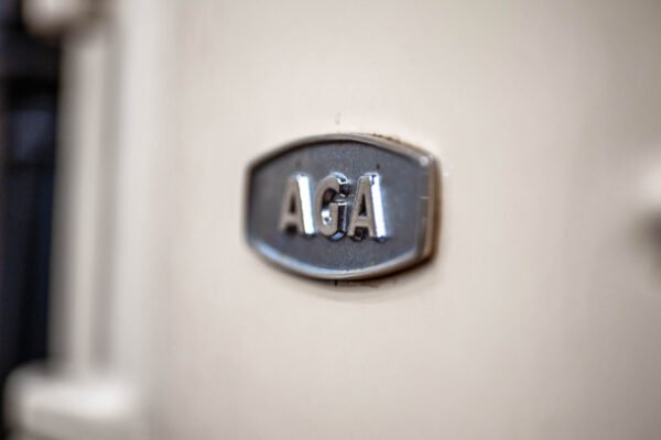Close-up of an AGA brand stove emblem, showcasing high-end kitchen appliance craftsmanship in a luxury home setting.