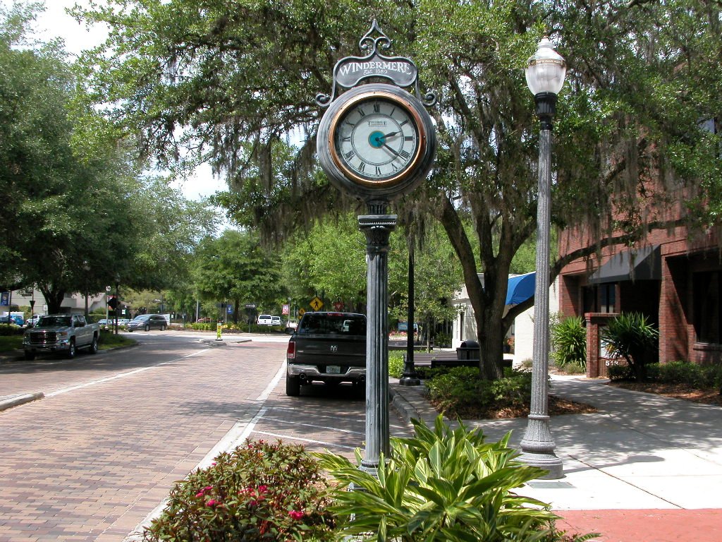 Windermere town clock surrounded by lush greenery and brick-paved street, symbolizing the local charm of Windermere, Florida, relevant to real estate market insights.