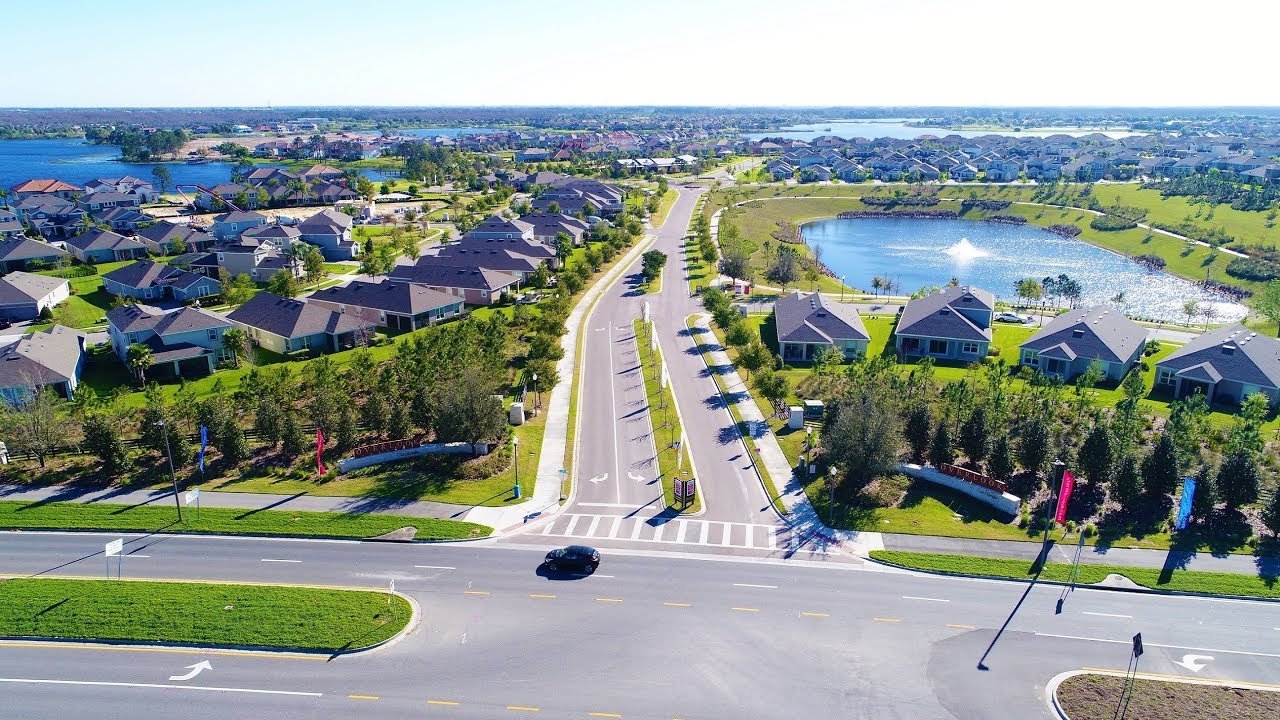 Aerial view of a suburban neighborhood in Windermere, Florida, showcasing houses, landscaped streets, and a nearby pond, relevant to the 2022 Windermere Real Estate Market Report by RTR Orlando.