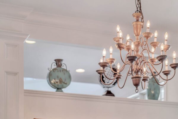 Chandelier with multiple light bulbs hanging in a bright interior, featuring decorative vases in the background, highlighting the elegant design of the home at 6264 Blakeford Drive, Windermere, FL.