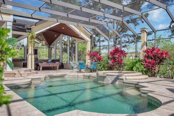 Luxury backyard oasis with a screened lanai, sparkling pool, and lush tropical landscaping at 6264 Blakeford Drive, Windermere, FL.