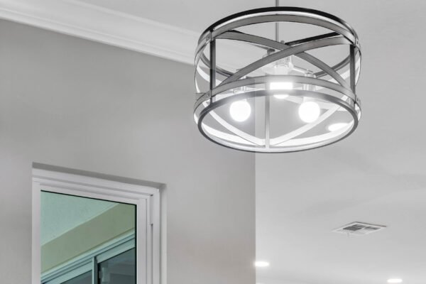 Modern chandelier illuminating a stylish interior space with gray walls and a window, showcasing contemporary design elements in the remodeled home at 13230 Fossick Road, Windermere, FL.