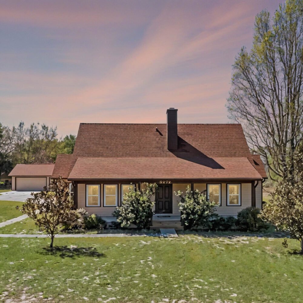 Charming single-family home at 9272 Gotha Road, Windermere, FL, featuring a welcoming front porch, landscaped yard, and expansive grounds, ideal for a homestead lifestyle with no HOA restrictions.